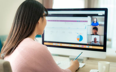 Woman working on a Teams call at a computer screen.