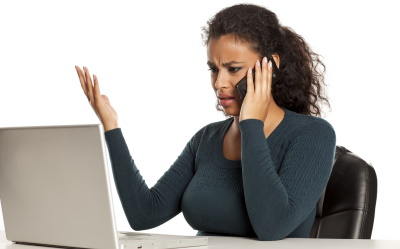Woman frustrated on phone call sat with laptop.