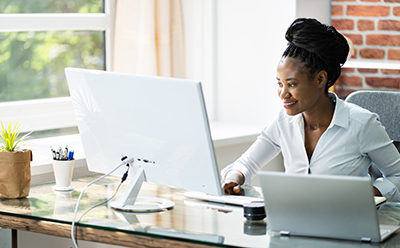 Woman in white working at computer. 